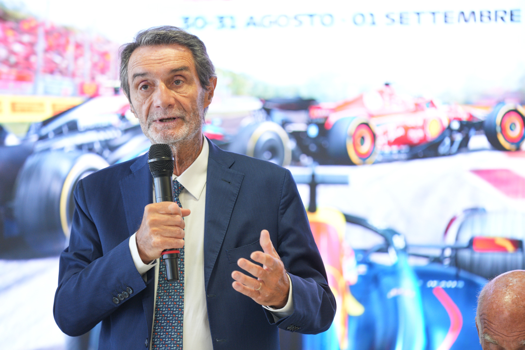 Il presidente Attilio Fontana durante un intervento, ha il microfono in mano e gesticola. Alle sue spalle grafiche inerenti il GP di Monza. Utilizzata per il suo appello al rinnovo tempestivo delle concessioni