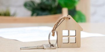 La foto ritrae una chiave su un tavolo con un portachiavi con un ciondolo a forma di casa. Utilizzata in occasione dell'articolo per alleanza housing sociale