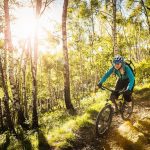 La foto ritrae una giovane donna tra i boschi sul lago di Como in mountain bike. Foto utilizzata per la Lake Como Bike Marathon