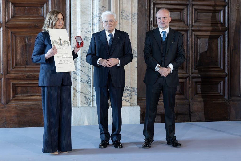 La foto ritrae il momento del ritiro del premio. In centro il Presidente Mattarella