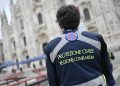 Una volontaria di Protezione civile davanti al Duomo di Milano: il ringraziamento dell’assessore in occasione della Giornata dedicata al volontariato