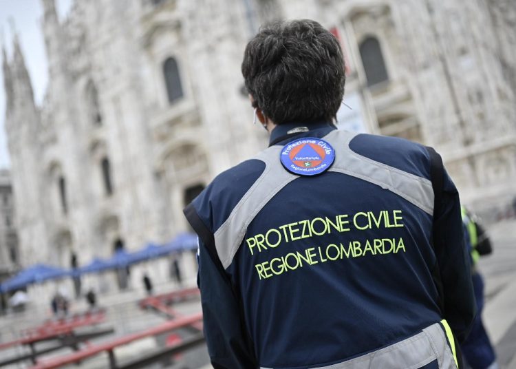Una volontaria di Protezione civile davanti al Duomo di Milano: il ringraziamento dell’assessore in occasione della Giornata dedicata al volontariato