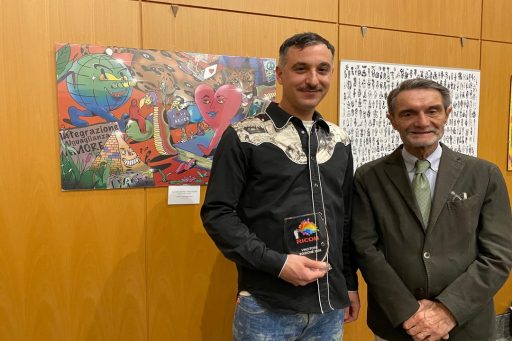 Alessandro Trevisan vincitore del Ricoh Urban Art Contest durante la premiazione a fianco al presidente Attilio Fontana. Il vincitore con il premio in mano davanti alla sua opera