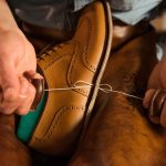 L'assessore allo Sviluppo economico Guidesi ha presentato i dati del primo trimestre 2025 relativi al settore della manifattura in Lombardia. Nella foto un calzolaio intento a cucire a mano una scarpa da uomo.