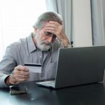 La foto ritrae un anziano truffato davanti al computer: l'impegno di Regione Lombardia per il contrasto alla criminalità con iniziative di prevenzione