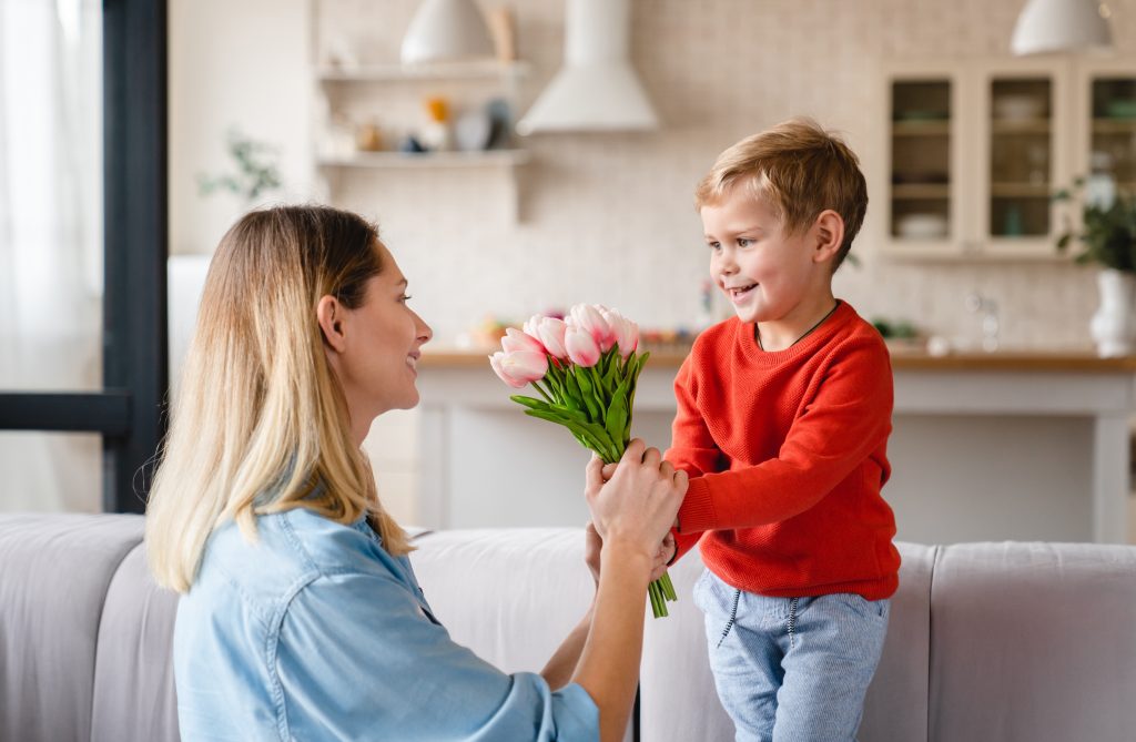 Festa della mamma, la foto ritrae un bambino che regala dei tulipani alla mamma