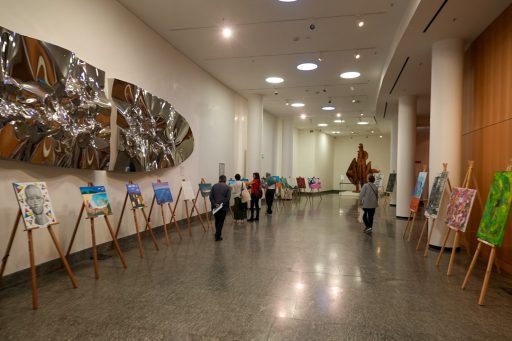 Panoramica Mostra Mapp nell'atrio dell'Auditorium Testori. La foto ritrae diverse opere e delle persone che visitano la rassegna
