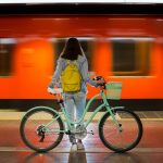 intermodalità stazioni ferroviarie, la foto mostra una ragazza con la sua bicicletta sulla banchina ferroviaria