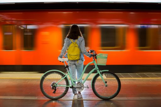 Intermobilità stazioni ferroviarie, la foto mostra una ragazza con la sua bicicletta sulla banchina ferroviaria