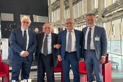 Foto di gruppo all'evento di premiazione a Goffredo Modena con il pieghevole di Mission Bambini. In centro Goffredo Modena e il sottosegretario Invernizzi