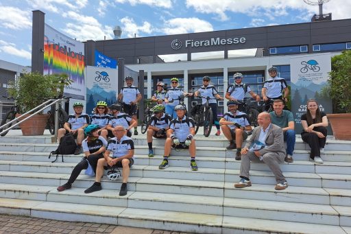 Alcuni ciclisti seduti su degli scalini in attesa dell'inizio del bike test della ciclovia Milano Monaco di Baviera