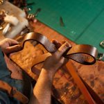 Regione Lombardia, in tema di giustizia, stanzia 2,6 milioni per l’inclusione attiva delle persone sottoposte a misure di esecuzione penale. Nella foto simbolica mani di artigiano che lavora una cintura in cuoio.