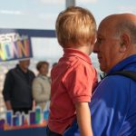 Un nonno con il nipote in braccio durante la festa dei nonni al Belvedere di Palazzo Lombardia