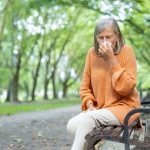 Una donna anziana starnutisce