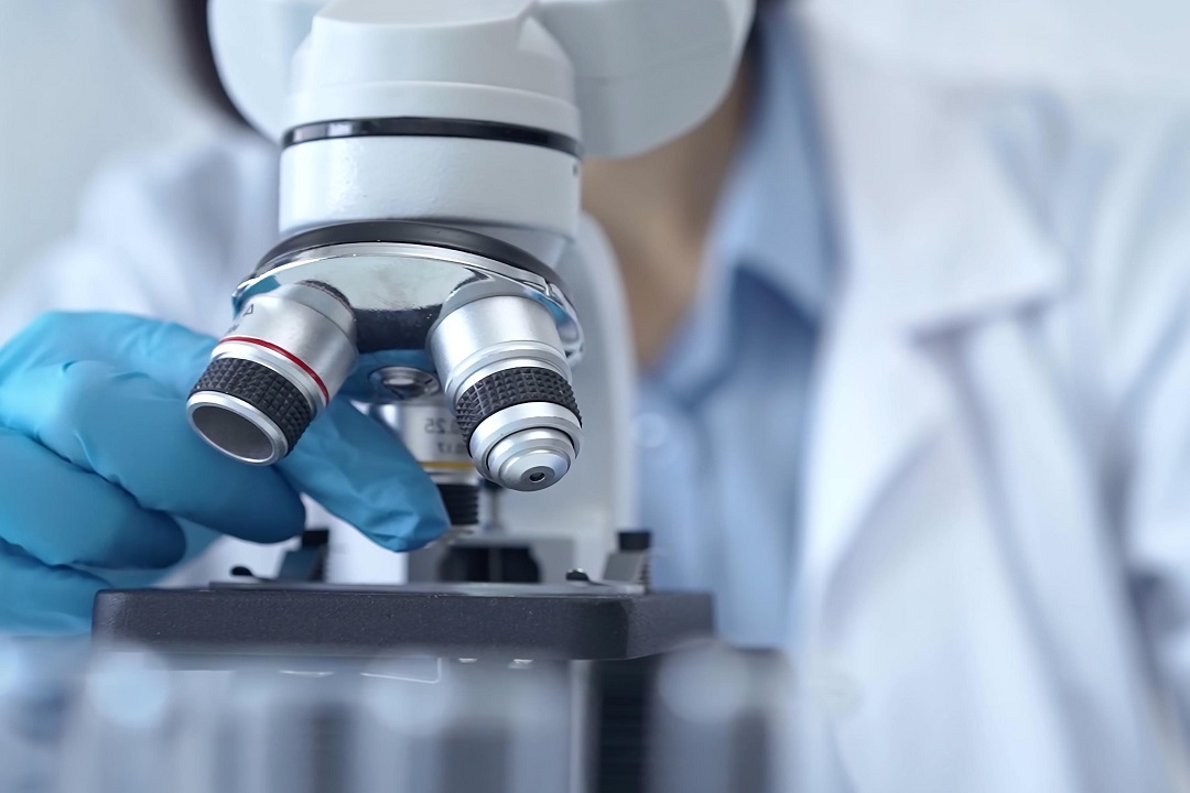 immagine di uno studioso al microscopio per dare idea di ricerca scientifica in lombardia