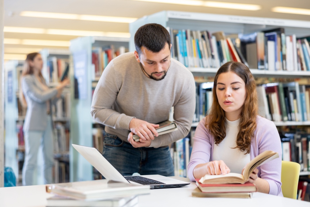 In foto due ragazzi in una biblioteca: da Regione Lombardia 290.000 euro come fondi per le biblioteche della Città metropolitana di Milano