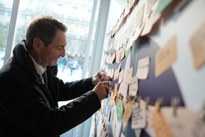In foto il presidente della Regione Lombardia, Attilio Fontana, mentre firma il suo biglietto sul ‘Muro degli impegni’ a Milano contro la violenza sulle donne