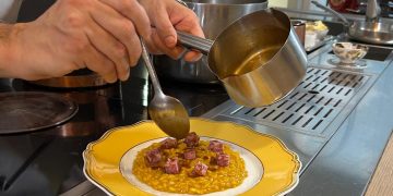 La tradizione del Natale si celebra anche a tavola con i tipici sapori lombardi 'rivisitati dallo chef stellato Alessandro Negrini . nella foto la preparazione del Risotto giallo allo zafferano.