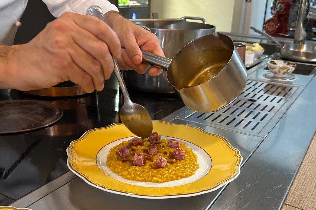 La tradizione del Natale si celebra anche a tavola con i tipici sapori lombardi 'rivisitati dallo chef stellato Alessandro Negrini . nella foto la preparazione del Risotto giallo allo zafferano.