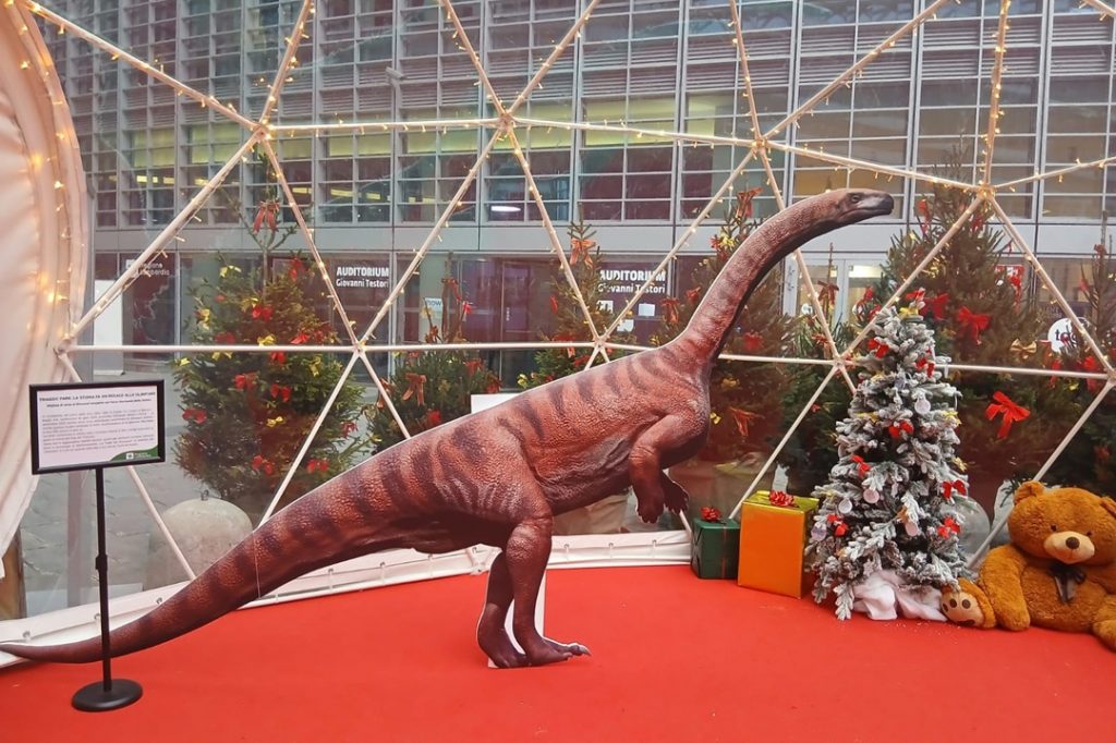 Una foto con 'Dino Fraele', uno dei dinosauri che oltre 200 milioni di anni fa popolavano la Lombardia nella piazza della Regione fino al 6 gennaio.