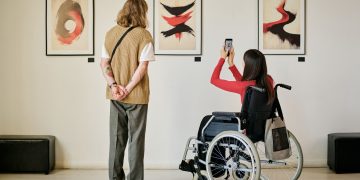 Due visitatori che guardano un quadro: presentata la web app dell’ADI Design Museum di Milano