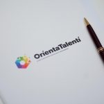 La foto mostra una cartellina con logo Orientatalenti 2026 con sopra appoggiata una penna. Foto scattata alla conferenza stampa di presentazione dell'evento che si terrà a Milano