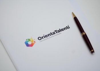 La foto mostra una cartellina con logo Orientatalenti 2026 con sopra appoggiata una penna. Foto scattata alla conferenza stampa di presentazione dell'evento che si terrà a Milano