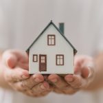 La foto mostra una casa in miniatura tenuta tra due mani. Foto utilizzata in occasione dell'articolo dei nuovi fondi di Regione Lombardia per l'housing sociale