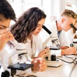 immagine di studenti con microscopio per dare l'idea del premio lombardia è ricerca studenti 2026