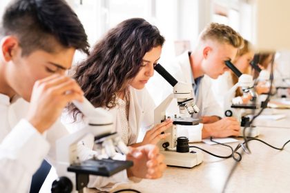 immagine di studenti con microscopio per dare l'idea del premio lombardia è ricerca studenti 2026