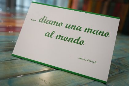 Cartellino della scultura Diamo una mano al mondo a Palazzo Lombardia