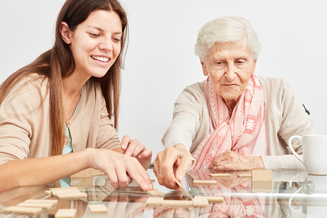 Una studentessa gioca a domino con una donna ospite di RSA per il progetto di welfare culturale
