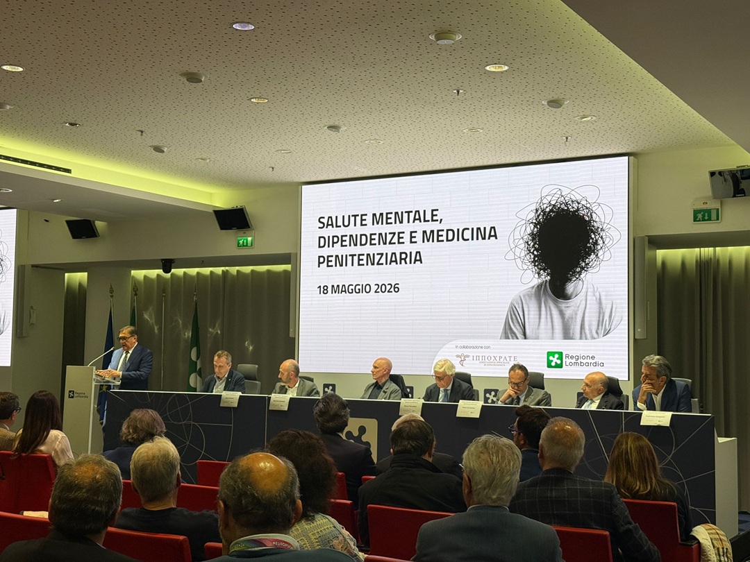 Convegno Associazione Ippocrate Salute mentale; l'immagine ritrae l'assessore La Russa durante il suo intervento; la visuale permette di vedere la locandina dell'evento trasmessa nel led e gli altri interlocutori seduti al tavolo.