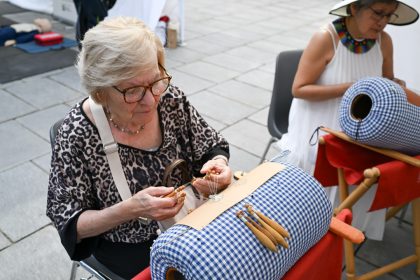 In foto una volontaria dello stand dei merletti di Cantù in piazza Città di Lombardia