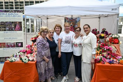 In foto le volontarie dello stand dedicato ai fiori di carta di Monte Isola (Brescia) in posa in piazza Città di Lombardia in occasione della Festa della Regione 2026