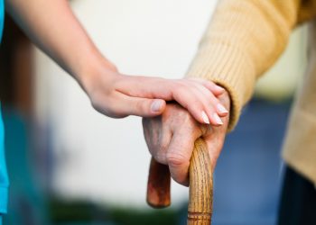 L'immagine ritrae una mano di un'anziano che si sorregge sul bastone e una mano di un'altra persona poggiata sopra. Immagine utilizzata per il Forum sostenibilità sociale che si è tenuto a Palazzo Lombardia
