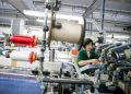 immagine di operaia in una azienda produttrice di filati: la Lombardia si conferma motore dell'economia italiana.