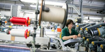 immagine di operaia in una azienda produttrice di filati: la Lombardia si conferma motore dell'economia italiana.