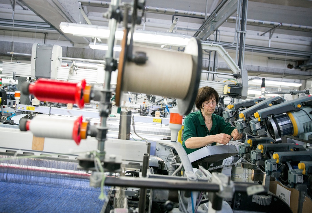 immagine di operaia in una azienda produttrice di filati: la Lombardia si conferma motore dell'economia italiana.
