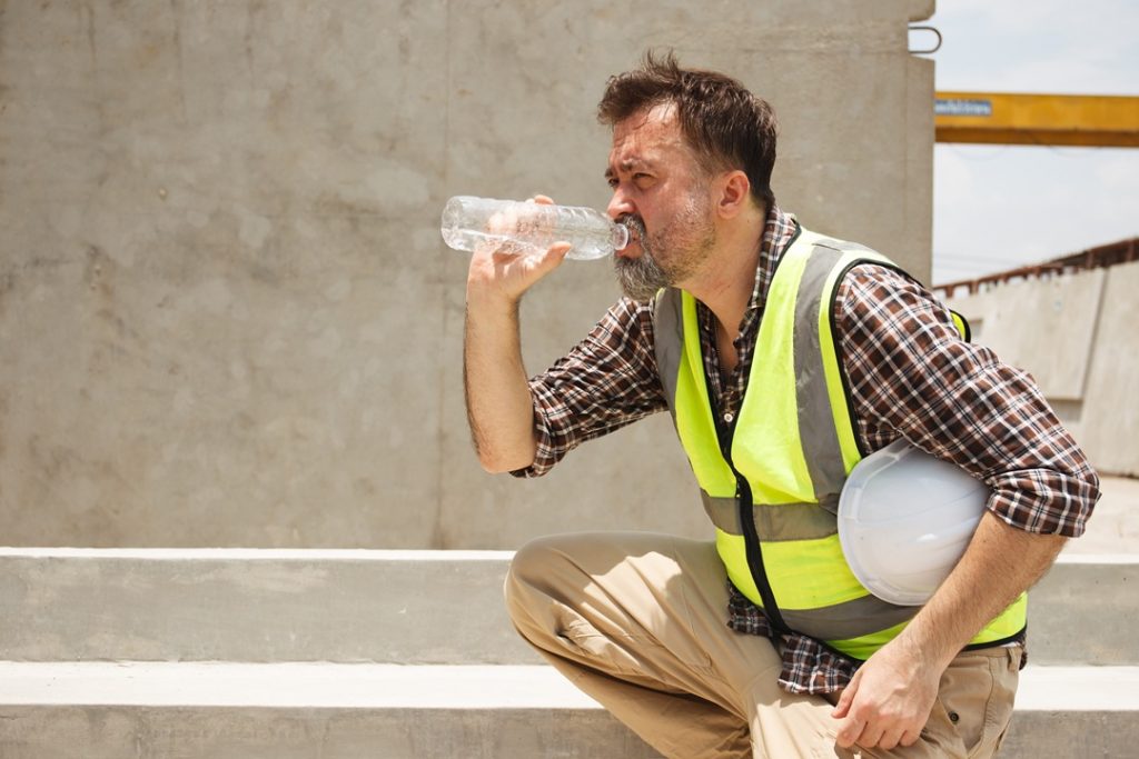 Nella foto un lavoratore si tutela dal caldo idratandosi. La regione Lombardia emana ordinanza a tutela dei lavoratori esposti al sole
