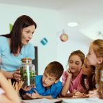 maestra che sta facendo lezione di educazione ambientale con dei bambini per dare l'idea delle iniziative promosse da Regione Lombardia