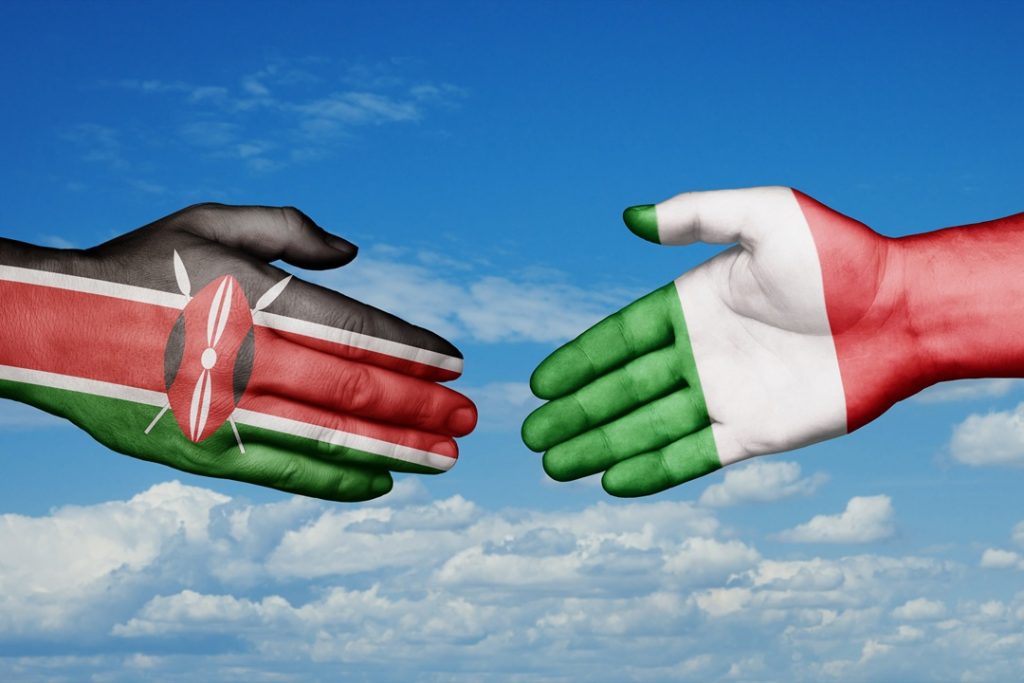 In foto due mani, una con la bandiera dell'Italia e l'altra del Kenya: i due paesi, nello specifico Regione Lombardia, sono coinvolti in un progetto di cooperazione internazionale