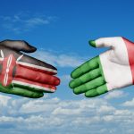 In foto due mani, una con la bandiera dell'Italia e l'altra del Kenya: i due paesi, nello specifico Regione Lombardia, sono coinvolti in un progetto di cooperazione internazionale
