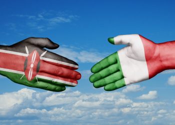 In foto due mani, una con la bandiera dell'Italia e l'altra del Kenya: i due paesi, nello specifico Regione Lombardia, sono coinvolti in un progetto di cooperazione internazionale