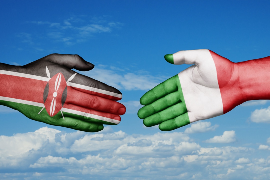 In foto due mani, una con la bandiera dell'Italia e l'altra del Kenya: i due paesi, nello specifico Regione Lombardia, sono coinvolti in un progetto di cooperazione internazionale