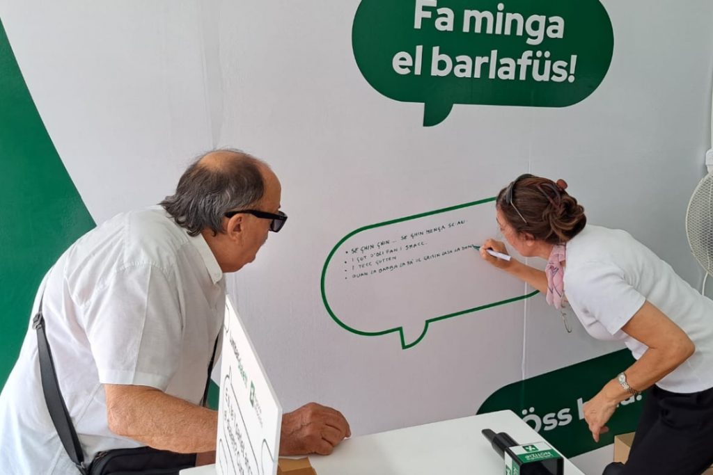 Lumbardialett Sagra delle Sagre. Una ragazza scrive sulla lavagnetta una frase in dialetto