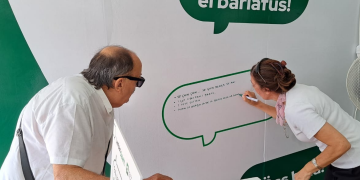 Lumbardialett Sagra delle Sagre. Una ragazza scrive sulla lavagnetta una frase in dialetto