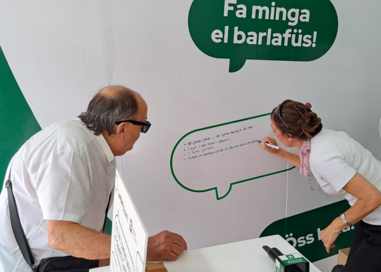 Lumbardialett Sagra delle Sagre. Una ragazza scrive sulla lavagnetta una frase in dialetto