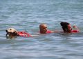 Sicurezza in mare, la foto mostra un cane salvagente che porta in salvo due persone