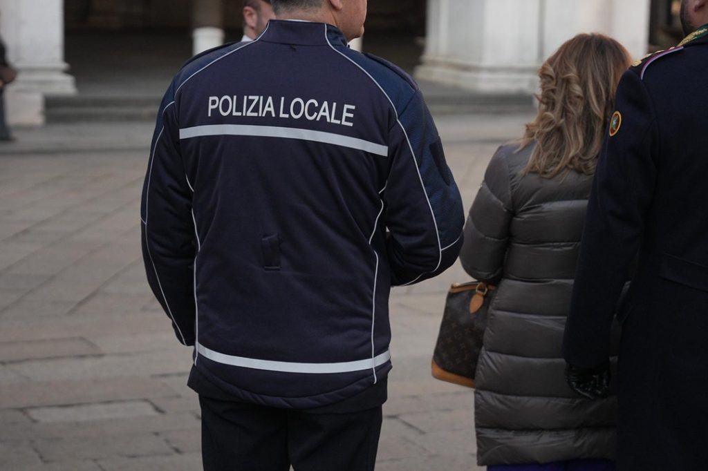 L'immagine mostra un agente della Polizia Locale da dietro, che mostra la scritta sulla divisa. Immagine utilizzata per Volontari Enti terzo settore.